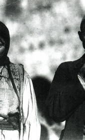 “Man in skullcap, semi-Western clothes, and a gun in his belt. To the left, a woman of the highlands in typical folk costume” (Photo: Carleton Coon 1929).