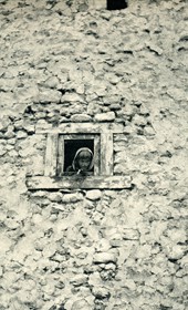 GM043: Child staring out a window in Theth (Photo: Giuseppe Massani, 1940).